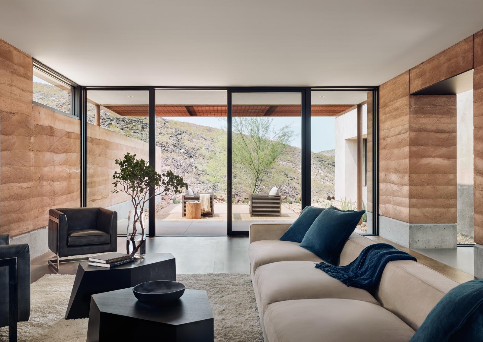 The rammed earth textures, colors and materials blend seamlessly with the surrounding desert.