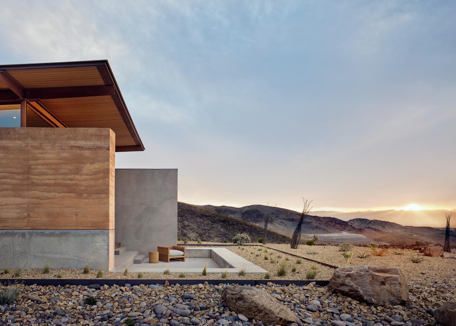 The rammed earth textures, colors and materials blend seamlessly with the surrounding desert.