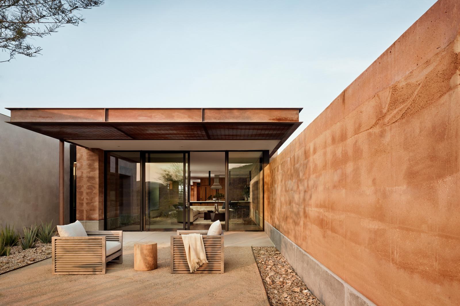 The rammed earth walls create outstretched wings that frame a private landscape while blocking the intense west exposure and northern winter winds.